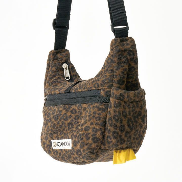 Crescent Bag in Leopard: side view with side pocket and poop bag pulled from the dispenser