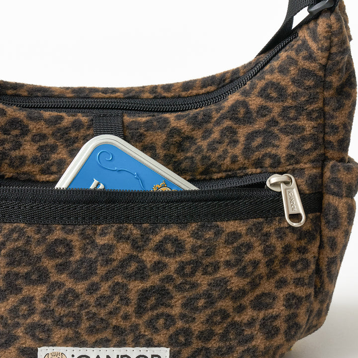 Crescent Bag in Leopard: front zip pocket with a small tin tucked inside, close-up