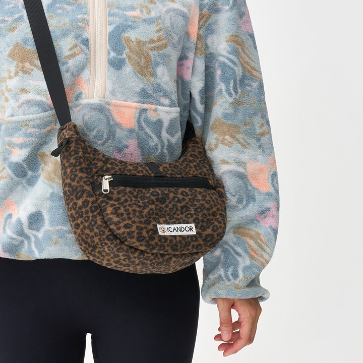 Crescent Bag in Leopard: worn crossbody over a fleece jacket