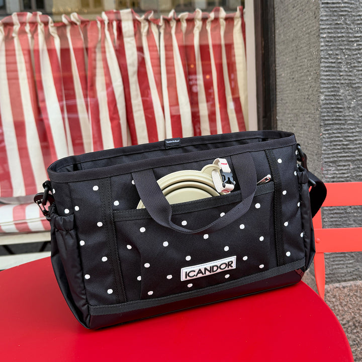 Urban Stroll Bag in Polka Dot: on a red table outdoors with a travel bowl in the front pocket