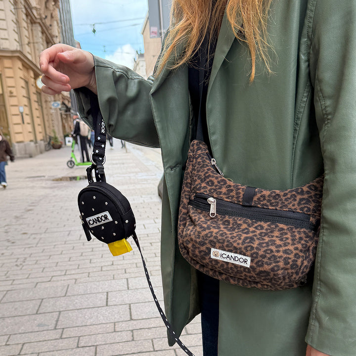Crescent Bag in Leopard: worn crossbody on a city street with a leash and Polka Dot Dingle Dangle Bag